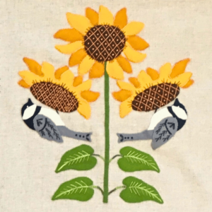 Wool Appliqué Block of wildlife quilt design by Carried Away Designs showing Two gray chickadees sitting under yellow sunflowers