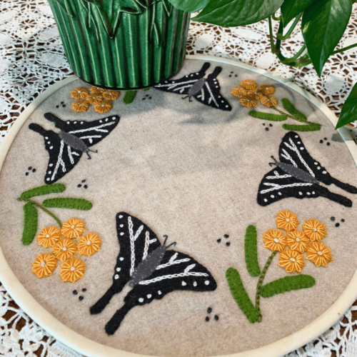Carried Away Designs linen-colored round table mat with black butterflies and yellow flowers