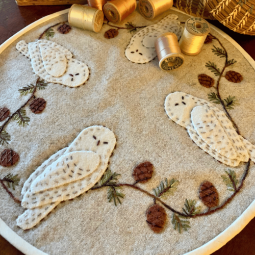 Carried Away Designs linen-colored round table mat with white sleepy owls and pinecones